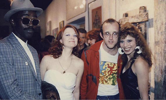 Abbildung zu: Fred Brathwaite alias "Fab 5 Freddy", Patti Astor, Keith Haring und Judy Rifka (v. l. n. r.), 1983, Foto: Baird Jones.