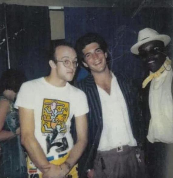 Abbildung zu: Keith Haring, John F. Kennedy Jr. und Fred Brathwaite alias "Fab 5 Freddy" backstage im Madison Square Garden auf einem Konzert von Madonnas "Virgin Tour", New York City, Juni 1985.