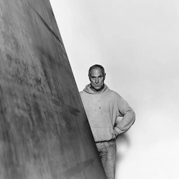 Abbildung zu: Richard Serra neben einer seiner Arbeiten, Foto: unbekannt. © Estate of Richard Serra / VG Bild-Kunst, Bonn 2026